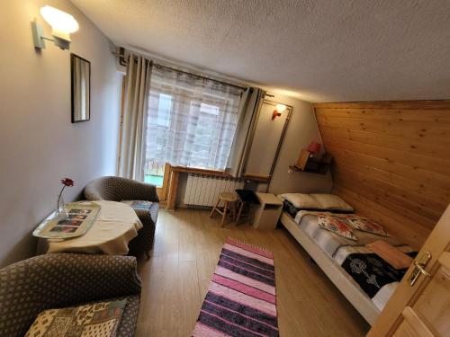 a small room with a bed and a couch and a table at Willa Helena in Zakopane