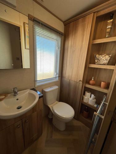 a bathroom with a toilet and a sink at Lapwing 60, Scratby - California Cliffs, Parkdean, sleeps 6, bed linen and towels included, no pets in Great Yarmouth