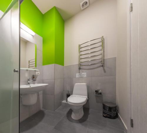 uma casa de banho com um WC e uma parede verde em Hotel Marenero em Odessa