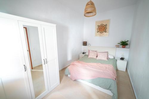 a small bedroom with a bed and a mirror at Casa Carmen in Haría