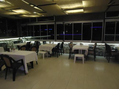 a dining room with white tables and chairs at Bells Motel in Seferihisar