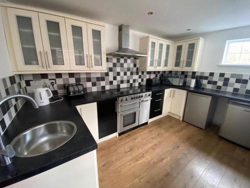 a kitchen with a sink and a counter top at Comfy-Stays - Ocean Road in South Shields