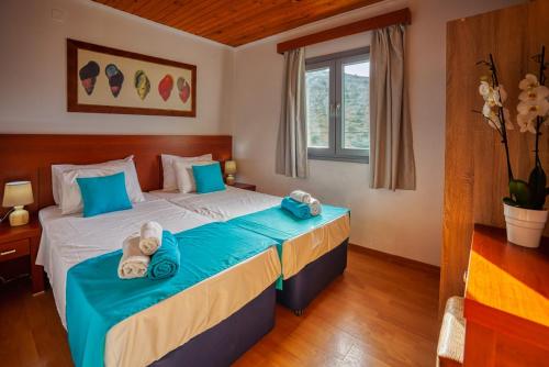 a bedroom with a bed with towels on it at Elounda Residence Resort & Waterpark in Elounda