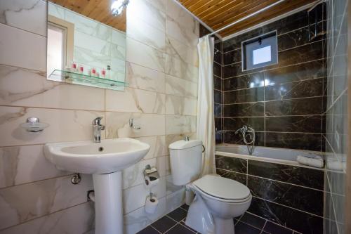 a bathroom with a toilet and a sink at Elounda Residence Resort & Waterpark in Elounda
