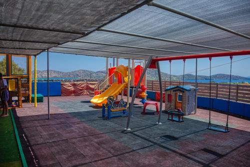 a play area with a slide and a playground at Elounda Residence Resort & Waterpark in Elounda