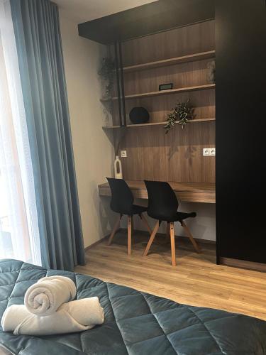 a bedroom with a desk and chairs and a bed at AMSTERDAM - nowy apartament w centrum z prywatnym zadaszonym parkingiem in Nowy Targ