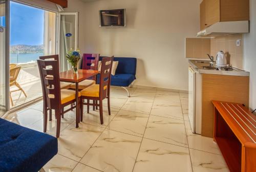 a kitchen and dining room with a table and chairs at Elounda Residence Resort & Waterpark in Elounda