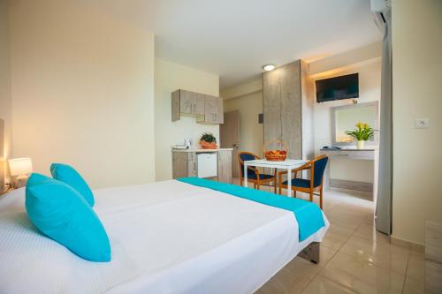 a bedroom with a bed and a table and a kitchen at Elounda Residence Resort & Waterpark in Elounda