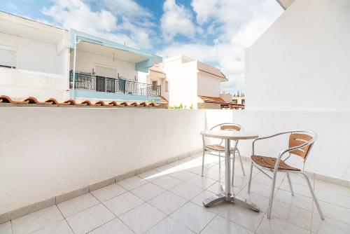a balcony with a table and chairs on a building at Acapulco 4 in Afantou