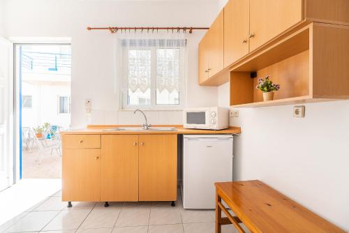 a kitchen with wooden cabinets and a white refrigerator at Acapulco 4 in Afantou