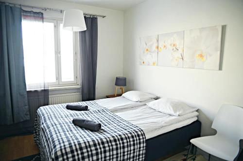 a bedroom with a bed with a checkered blanket at Scandinavian Sweet home 30 Työmiehenkatu 2 in Helsinki