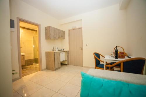 a living room with a table and a kitchen at Elounda Residence Resort & Waterpark in Elounda
