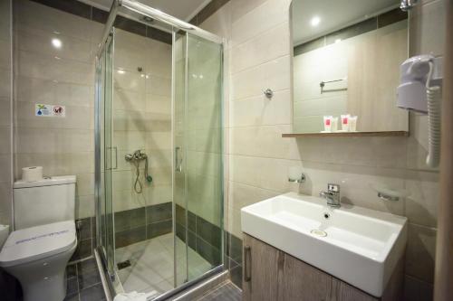 a bathroom with a sink and a shower and a toilet at Elounda Residence Resort & Waterpark in Elounda