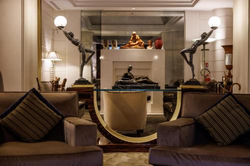 a room with a mirror and a couch and chairs at Hotel Lord Byron - Small Luxury Hotels of the World in Rome