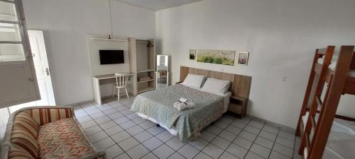ein Schlafzimmer mit einem Bett, auf dem ein Stofftier liegt in der Unterkunft Floripa Hostel CENTRO in Florianópolis