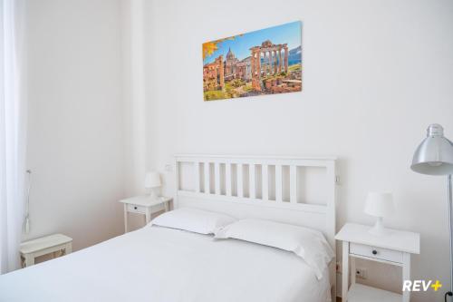 ローマにあるMecenate Apartment Colosseumの白いベッドと壁に絵画が飾られたベッドルーム1室