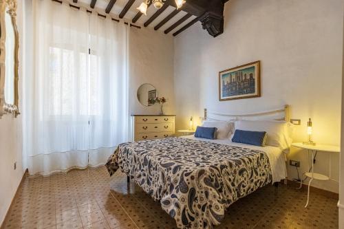 een slaapkamer met een bed en een raam bij Appartamenti Panoramici Piazza delle Erbe in San Gimignano