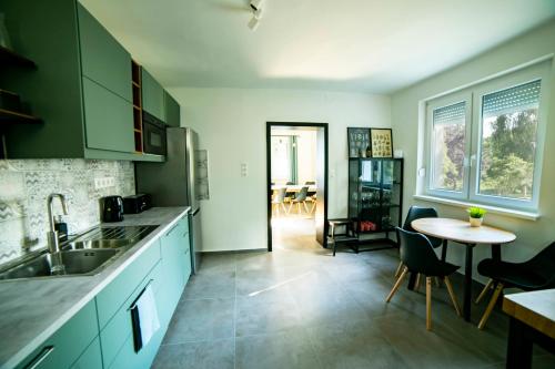 福紐德的住宿－Kégli_Fonyód，厨房配有绿色橱柜和桌椅