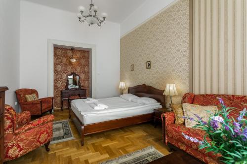 ein Hotelzimmer mit einem Bett und zwei Stühlen in der Unterkunft The Spiski Palace Apartments in Krakau