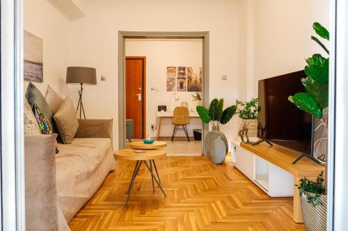 ein Wohnzimmer mit einem Sofa und einem Tisch in der Unterkunft Newly Renovated Apartment 7 min walk from Acropolis in Athen
