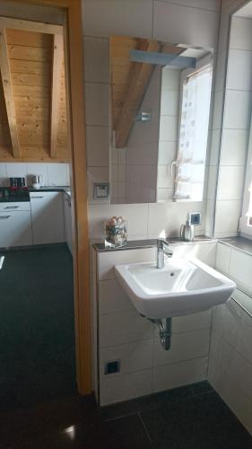 ein weißes Waschbecken in einer Küche mit Fenster in der Unterkunft Schöne Loftwohnung ca. 9km vom Bodensee entfernt in Stockach