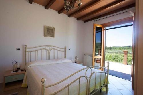 a bedroom with a bed and a sliding glass door at Agriturismo San Giuseppe in Gavorrano