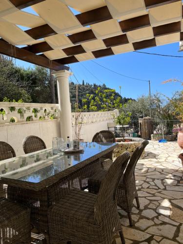 a patio with a table and chairs on a patio at Villa Ampelaki "30 meters to beach" in Paleokastritsa