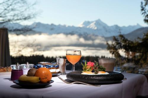 a table with a plate of food and a glass of wine at Hotel Royal in Crans-Montana
