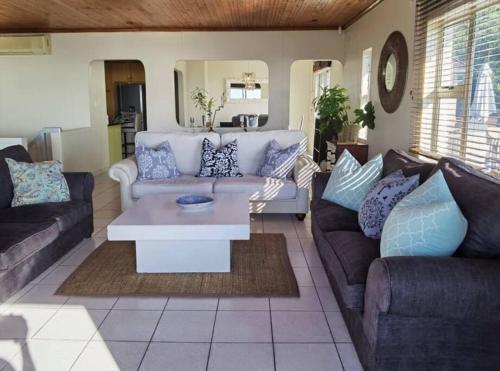 Sala de estar con sofás y mesa de centro en Tinley Manor Beach House en Tinley Manor