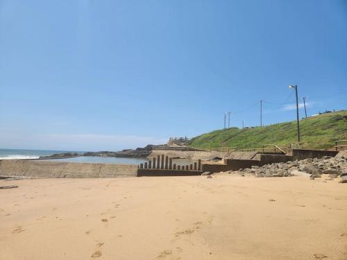 a sandy beach with footprints in the sand at Tinley Manor Beach House in Tinley Manor