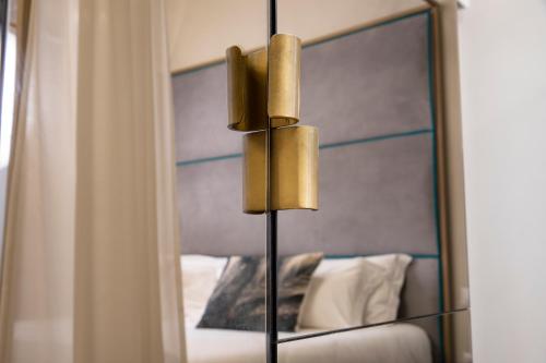 a mirror next to a bed in a bedroom at Ricasoli Garden Relais in Florence