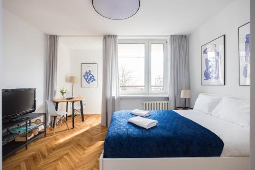 ワルシャワにあるRiverside Comfort Studioのベッドルーム1室(大型ベッド1台、青い毛布付)