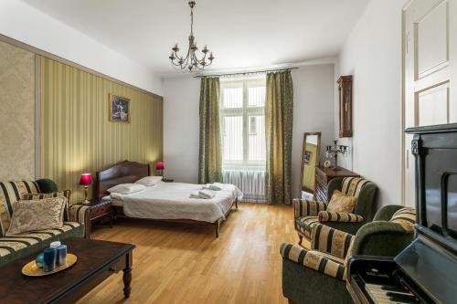 ein Wohnzimmer mit einem Bett, einem Sofa und Stühlen in der Unterkunft The Spiski Palace Apartments in Krakau