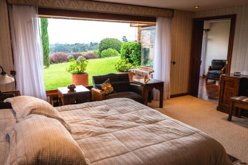 a bedroom with a bed and a large window at Villa Los Lagos in Bogotá