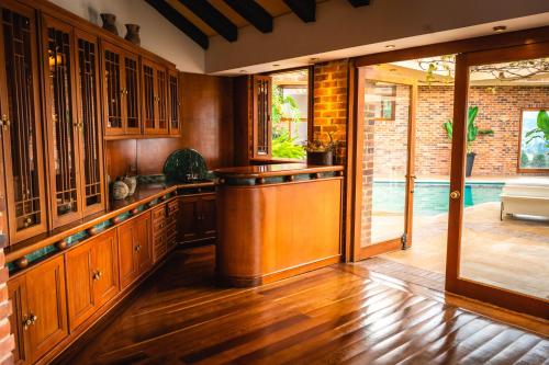 a kitchen with wooden cabinets and a bar in it at Villa Los Lagos in Bogotá