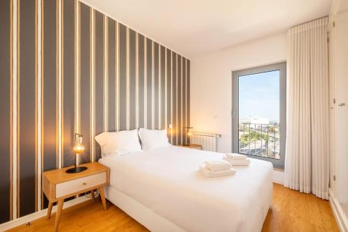 a bedroom with a large white bed and a window at GuestReady - Pedra Residence near Marina in Lisbon