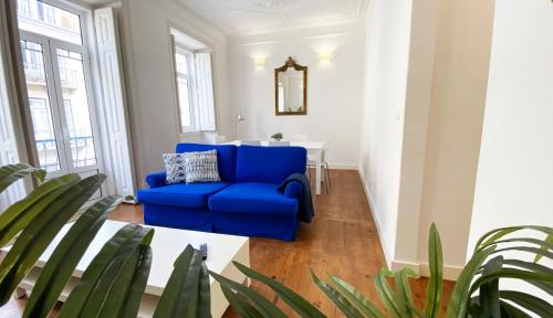 a blue couch in a living room with a table at House On The Hill Lisbon in Lisbon