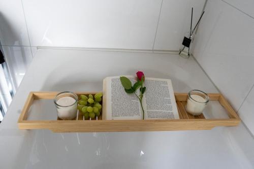 a shelf with a book and a flower and some apples at Ferienwohnung Hertreiter in Dingolfing 110qm in Dingolfing