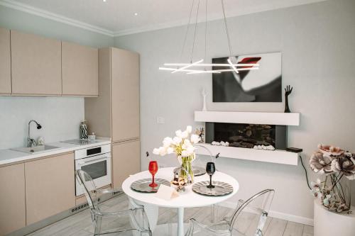 eine Küche mit einem weißen Tisch und Stühlen in einem Zimmer in der Unterkunft AM Apartments 13 Timisoara in Timişoara