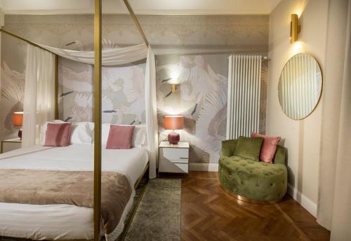 a bedroom with a canopy bed and a green chair at Ricasoli Garden Relais in Florence