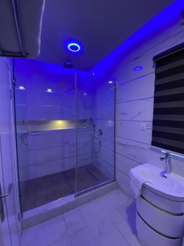 a bathroom with a toilet and a shower with blue lights at 2-Bedroom Apartment in Ikoyi in Lagos
