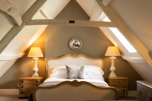 sypialnia z łóżkiem i 2 lampkami na poddaszu w obiekcie New Inn at Coln w mieście Coln Saint Aldwyn
