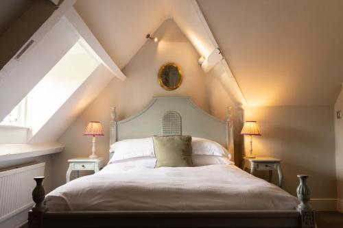 New Inn at Coln في Coln Saint Aldwyn: غرفة نوم بسرير أبيض في العلية