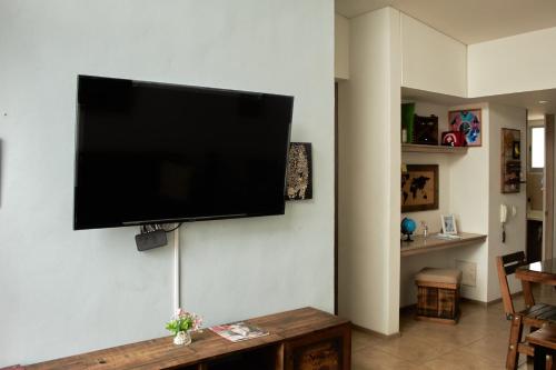 einen Flachbild-TV, der an einer Wand hängt in der Unterkunft Apartamento completo tipo vintage en villeta in Villeta