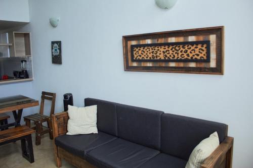 ein Wohnzimmer mit einem schwarzen Sofa und einem Tisch in der Unterkunft Apartamento completo tipo vintage en villeta in Villeta