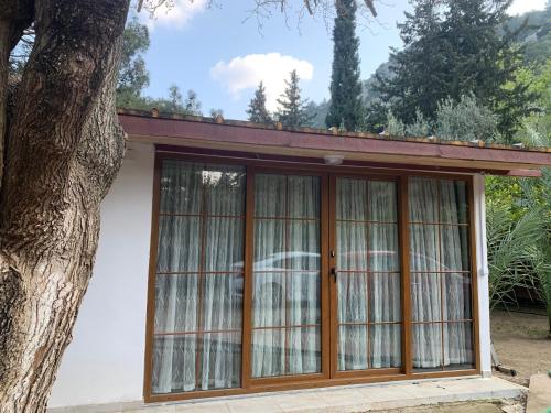 a large glass door with a car behind it at Adabella Pension in Cıralı