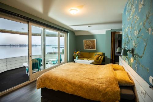 ein Schlafzimmer mit einem großen Bett und einem großen Fenster in der Unterkunft Villa Braas in Breukeleveen