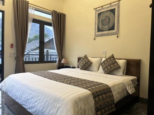 sypialnia z dużym łóżkiem i oknem w obiekcie Duong Thim Homestay Mai Chau w mieście Mai Châu