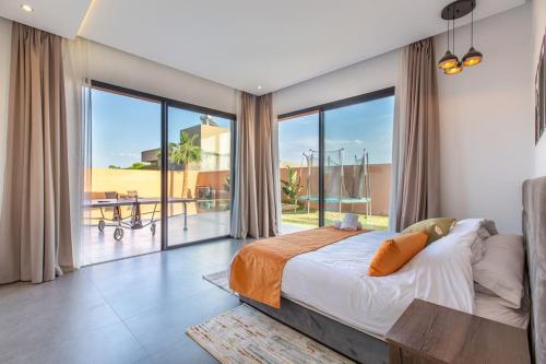 - une chambre avec un grand lit et une grande fenêtre dans l'établissement Villa Menara, personnels inclus, à Marrakech