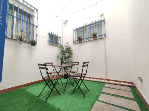 stół i krzesła na balkonie z zieloną trawą w obiekcie Covadonga Suite Home w Sewilli